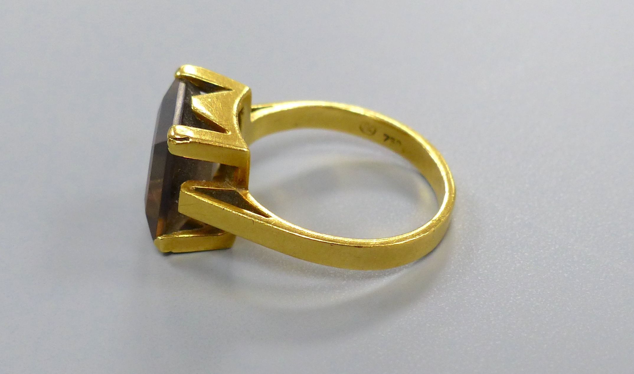 A yellow metal(stamped 750) and smoky quartz set dress ring, size M, gross 5.2 grams.